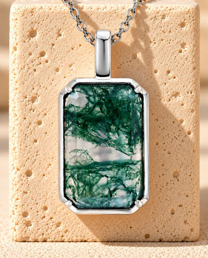 Collar de Ágata Musgosa Colgante Rectangular en Plata 925 - colgado sobre un bloque de travertino