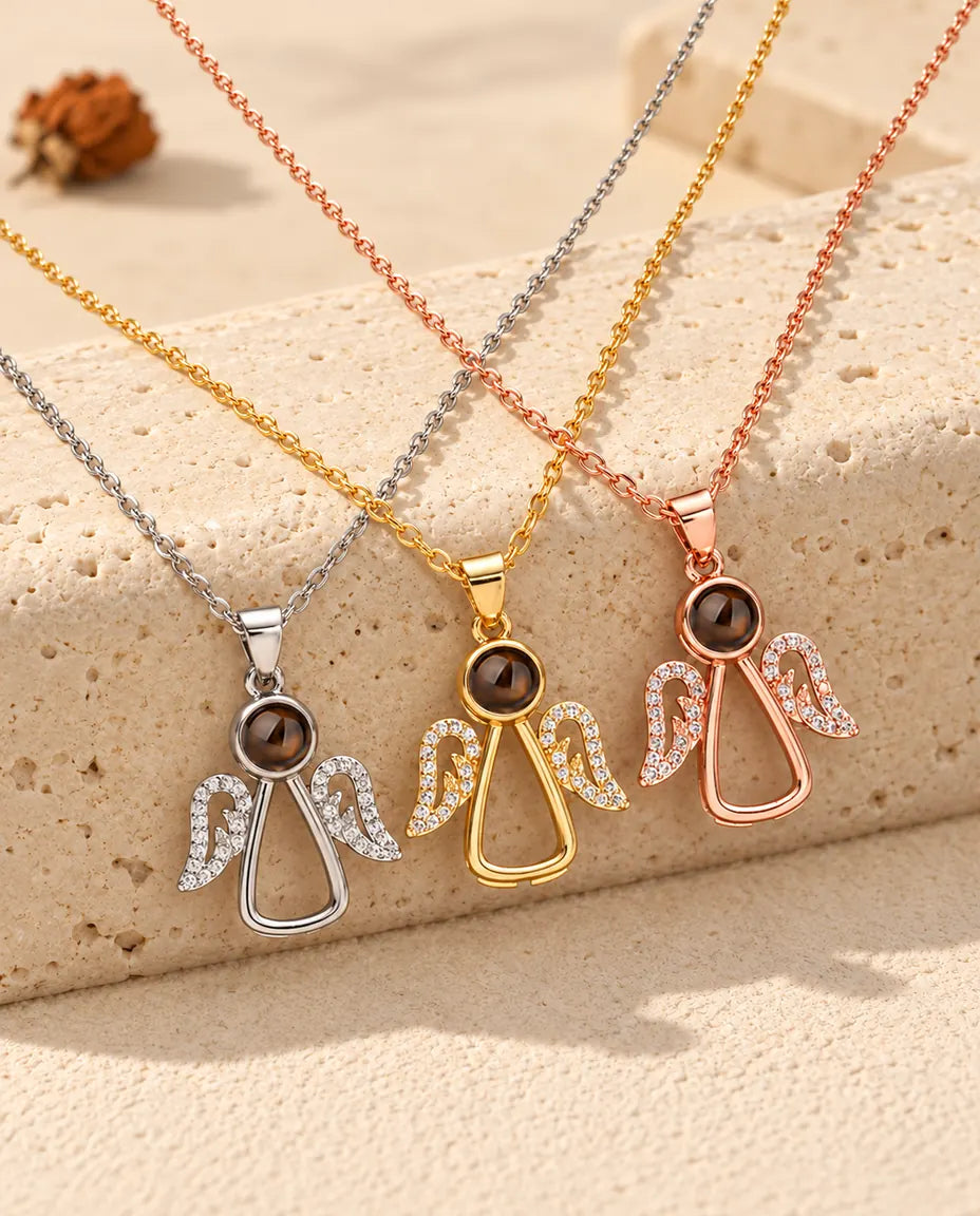 Collares de ángel plateado, dorado y color oro rosa colgados sobre un bloque de travertino
