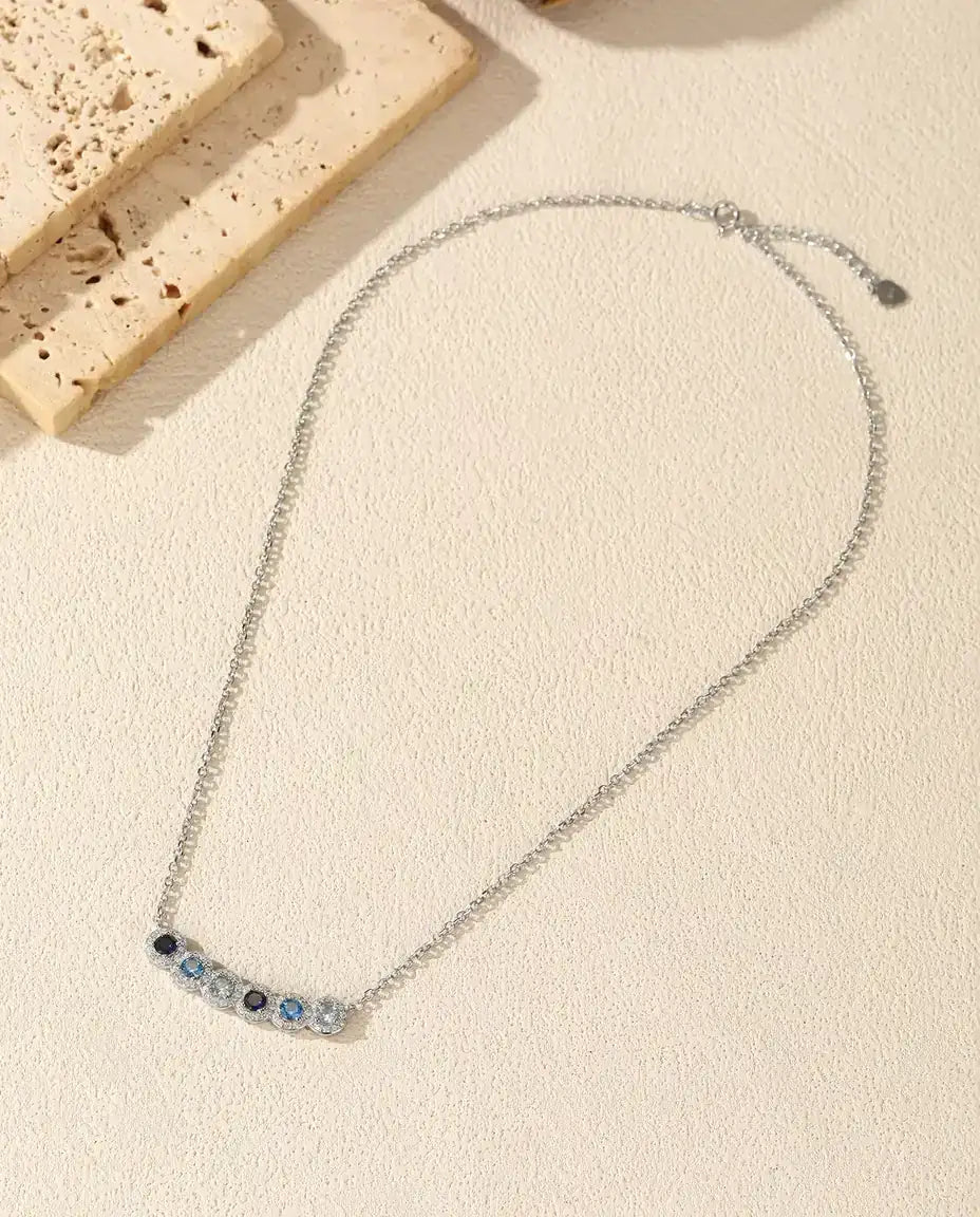 Collar Barra Degradado Azul - seis piedras azules con halo de pavé, barra curva de 34 mm, plata de ley 925