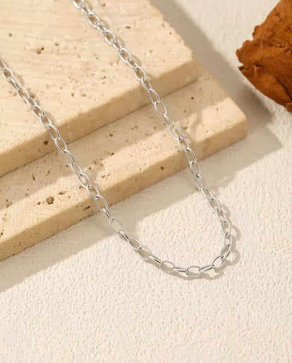 Collar Cadena Forzada en Plata 925 - cadena sobre una losa de travertino, primer plano
