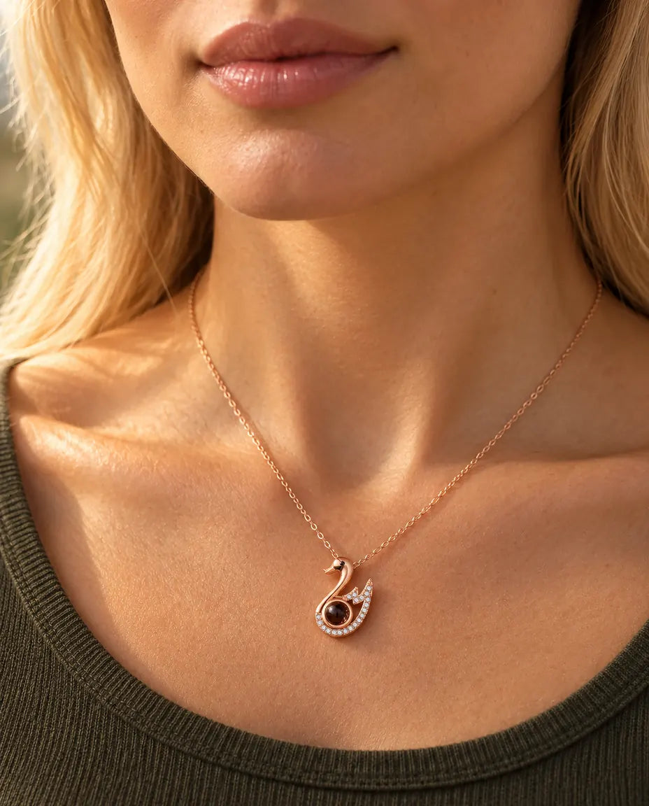 Mujer con un top verde oliva de punto que lleva el collar de cisne en color oro rosa con foto dentro