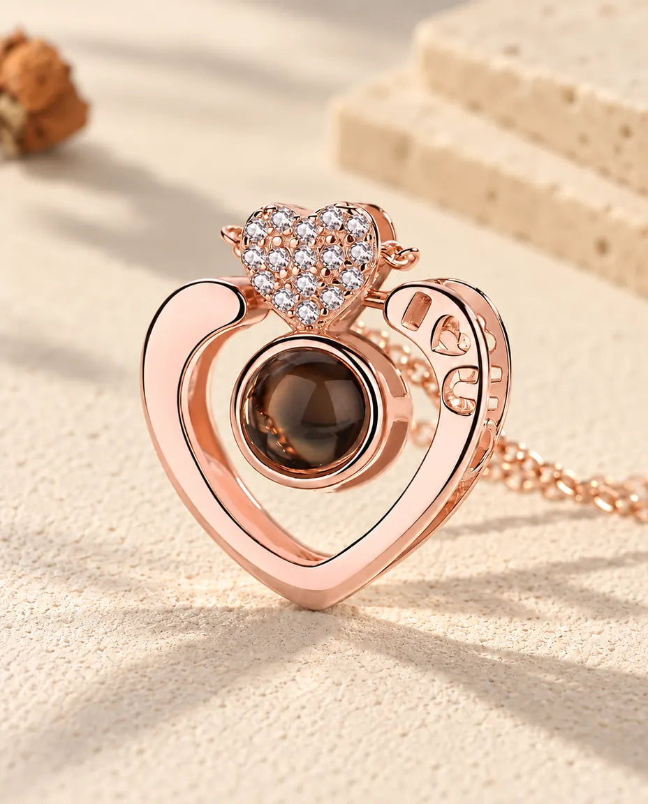 Primer plano del corazón abierto en color oro rosa con la I, el corazón y la U calados y el corazoncito de circonitas