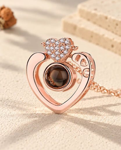 Primer plano del corazón abierto en color oro rosa con la I, el corazón y la U calados y el corazoncito de circonitas