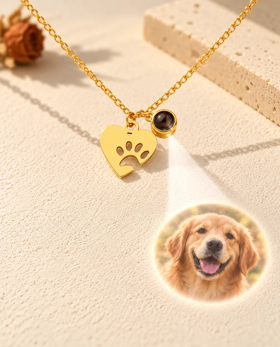 Luz que atraviesa la bolita marrón del collar dorado de huella y muestra la foto de un golden retriever