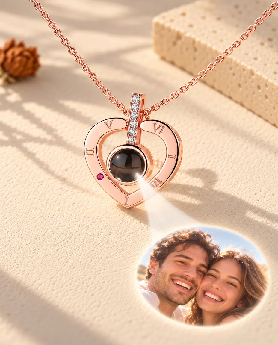 Collar de números romanos en color oro rosa cuya bola muestra una foto de pareja sobre yeso color crema