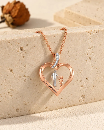 Collar corazón padre e hija colgando del borde de un bloque de travertino