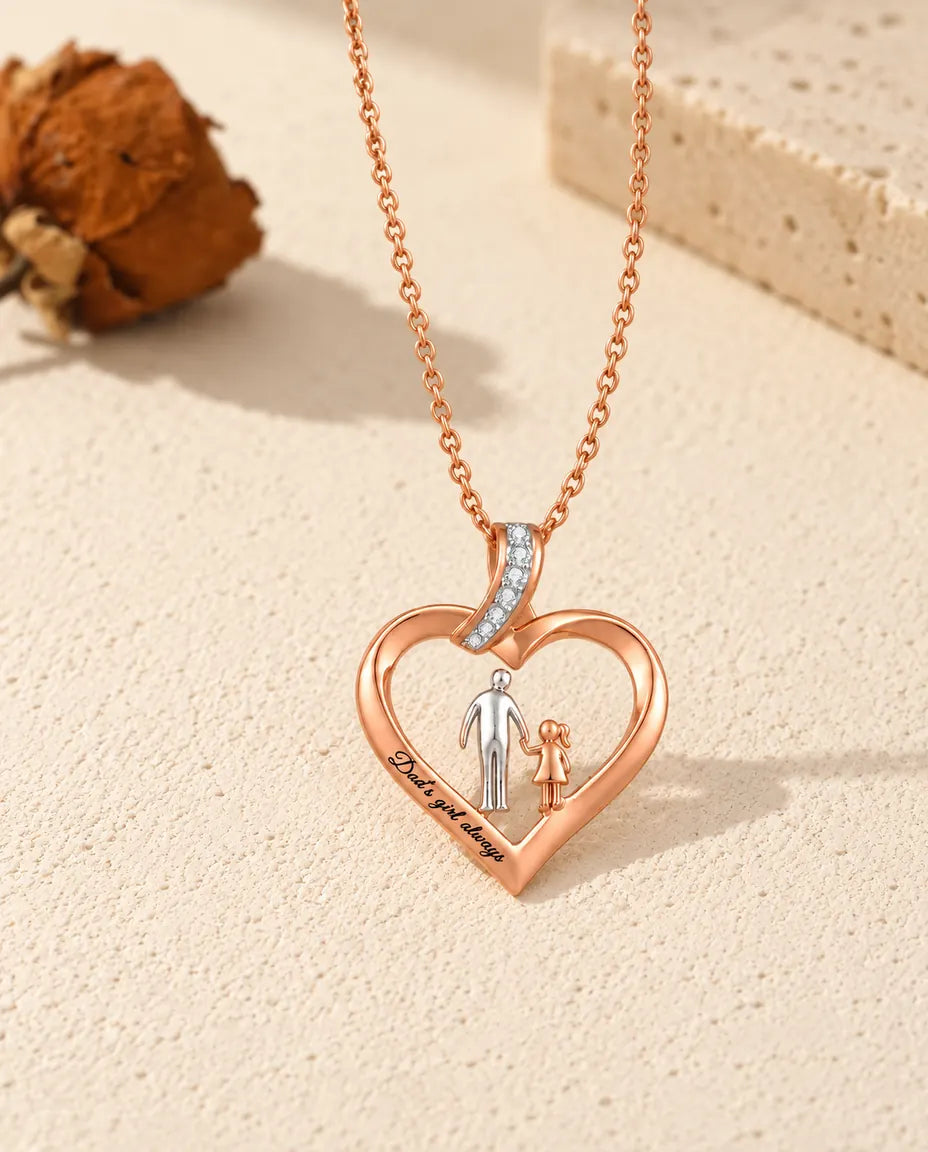 Collar corazón grabado papá e hija extendido en plano junto a su cadena color oro rosa