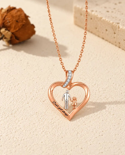 Collar corazón grabado papá e hija extendido en plano junto a su cadena color oro rosa
