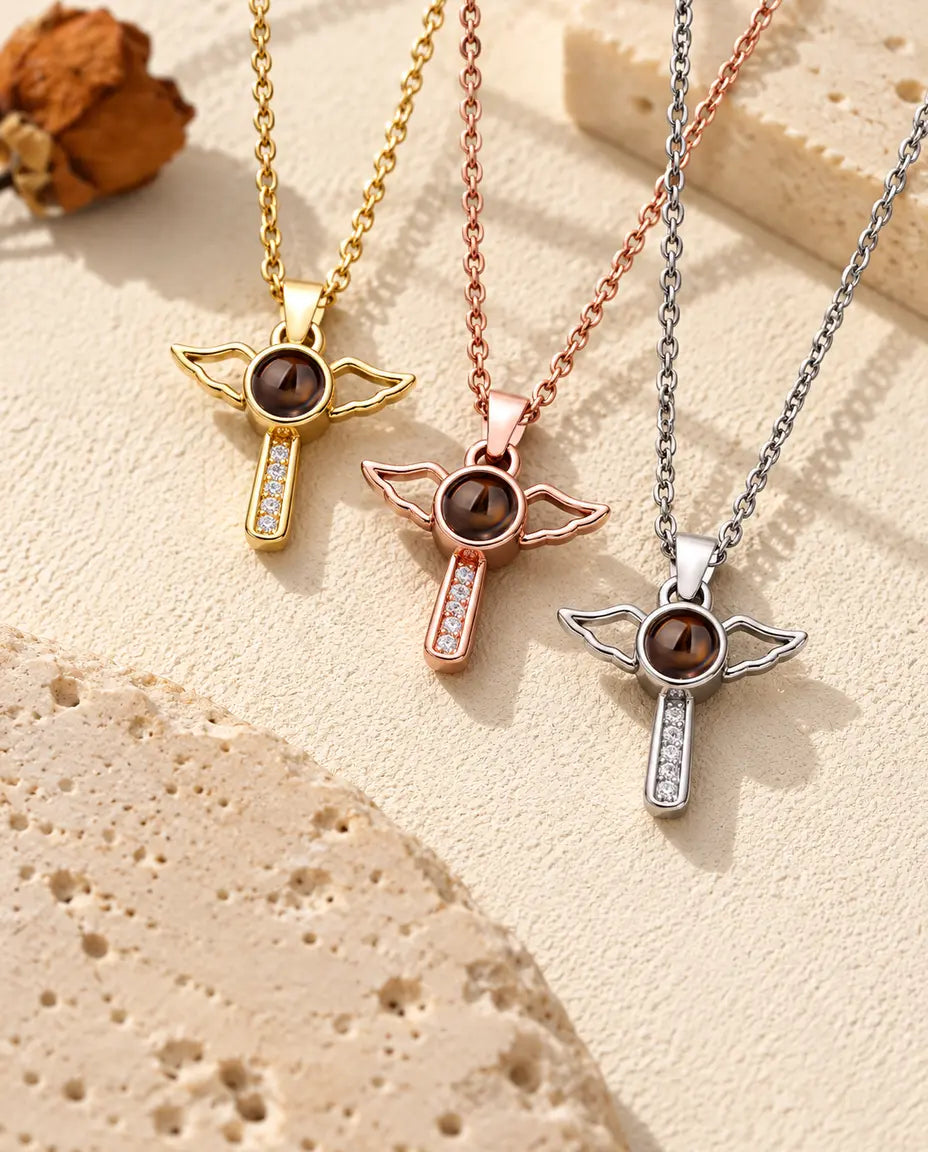 Cruces con alas en dorado, color oro rosa y plateado colgadas una junto a otra