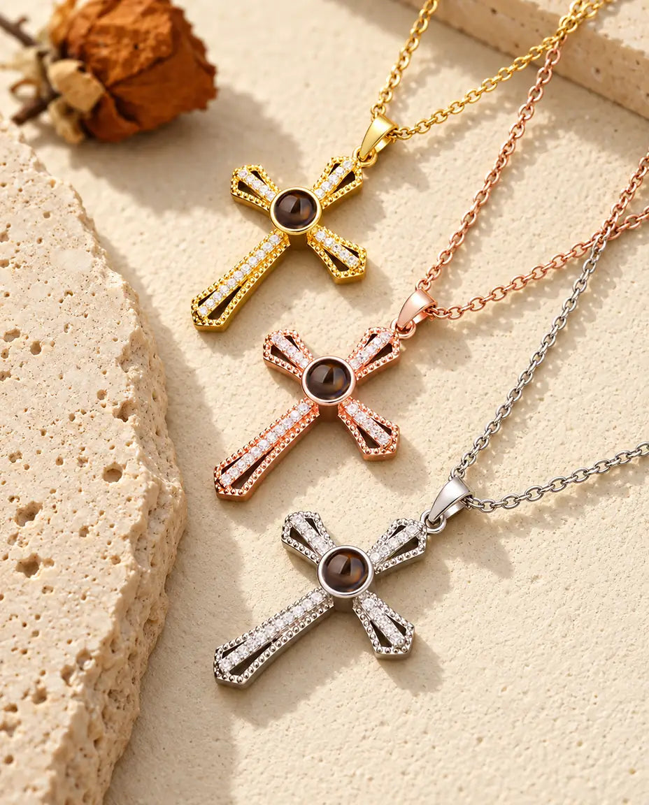 Collares cruz en dorado, color oro rosa y plateado, apilados junto a una losa de travertino