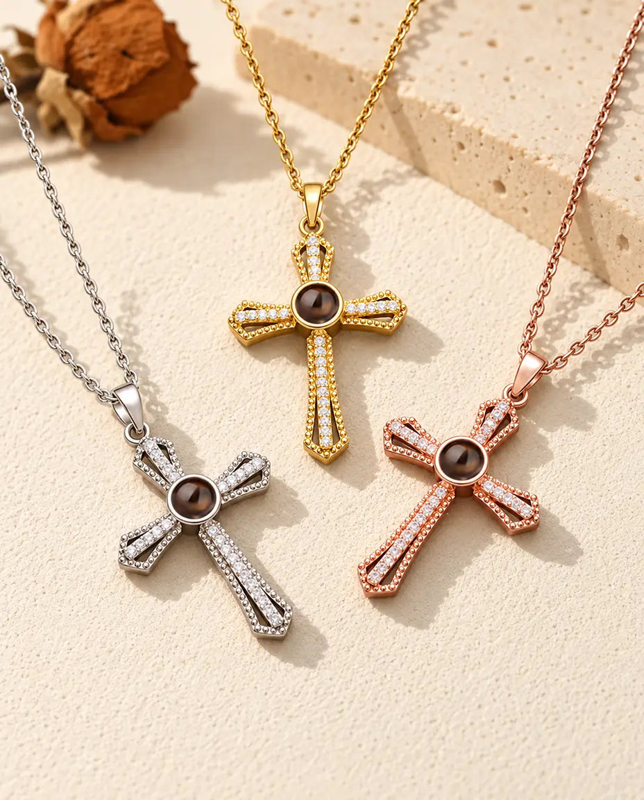 Los tres colores del collar cruz con foto dentro, dispuestos sobre yeso color crema