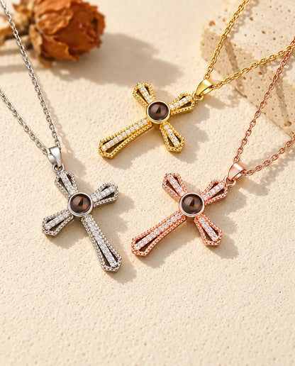 Collares cruz plateado, dorado y color oro rosa con bolas marrones de proyección, junto a una losa de travertino