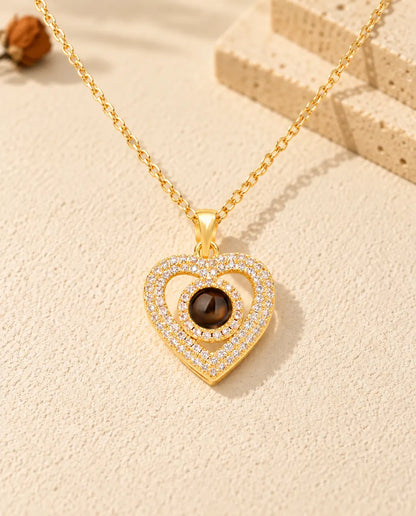 Vista frontal del collar dorado de doble corazón con circonitas y foto dentro