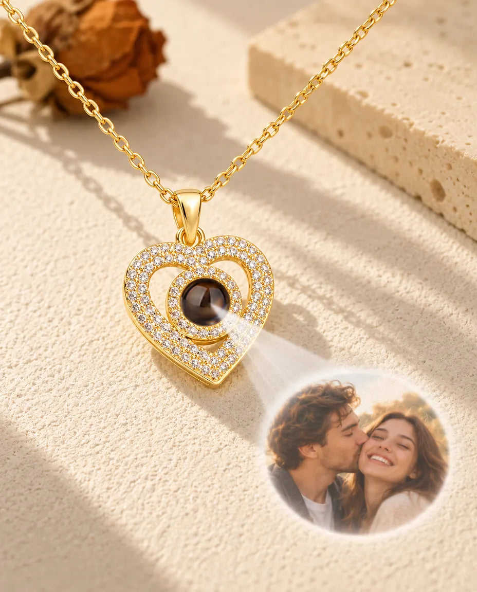 Luz que atraviesa la bola marrón del collar dorado de doble corazón y muestra la foto de una pareja