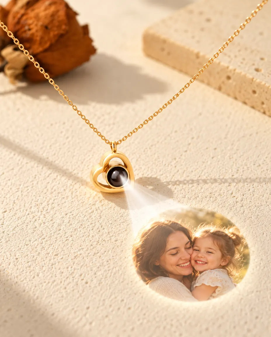 Collar de doble corazón dorado cuya bola muestra una foto de madre e hija sobre yeso color crema
