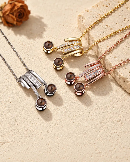 Collares plateado, dorado y color oro rosa con dos bolas de proyección cada uno, junto a una losa de travertino