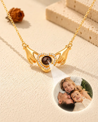 Luz que atraviesa la bola marrón del collar dorado de manos y corazón, mostrando una foto de familia