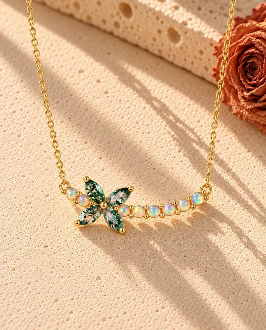 Collar Flor de Ágata Musgosa en Plata 925 Chapada en Oro - sobre una superficie clara con textura junto a un bloque de travertino