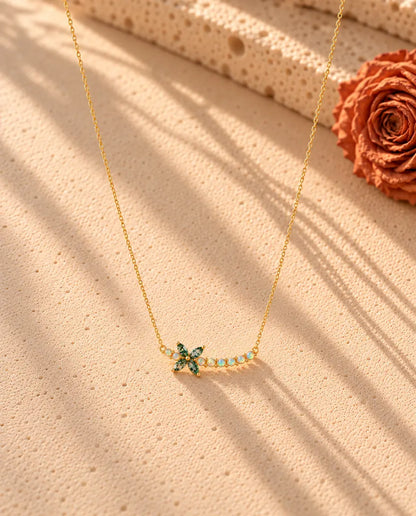 Collar Flor de Ágata Musgosa en Plata 925 Chapada en Oro - el collar completo extendido en una larga V sobre una superficie clara con textura