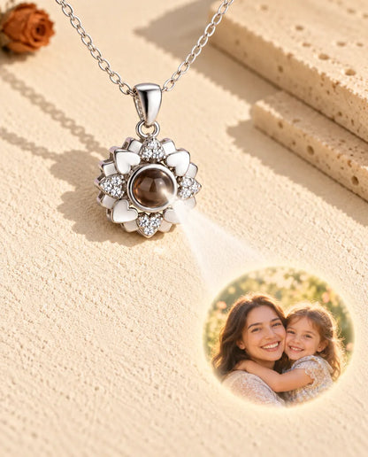 Collar de flor de corazones plateado cuya bola muestra una foto de madre e hija sobre yeso