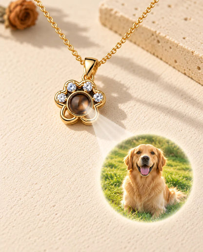 Collar de huella dorado cuya bola muestra la foto de un golden retriever sobre yeso crema