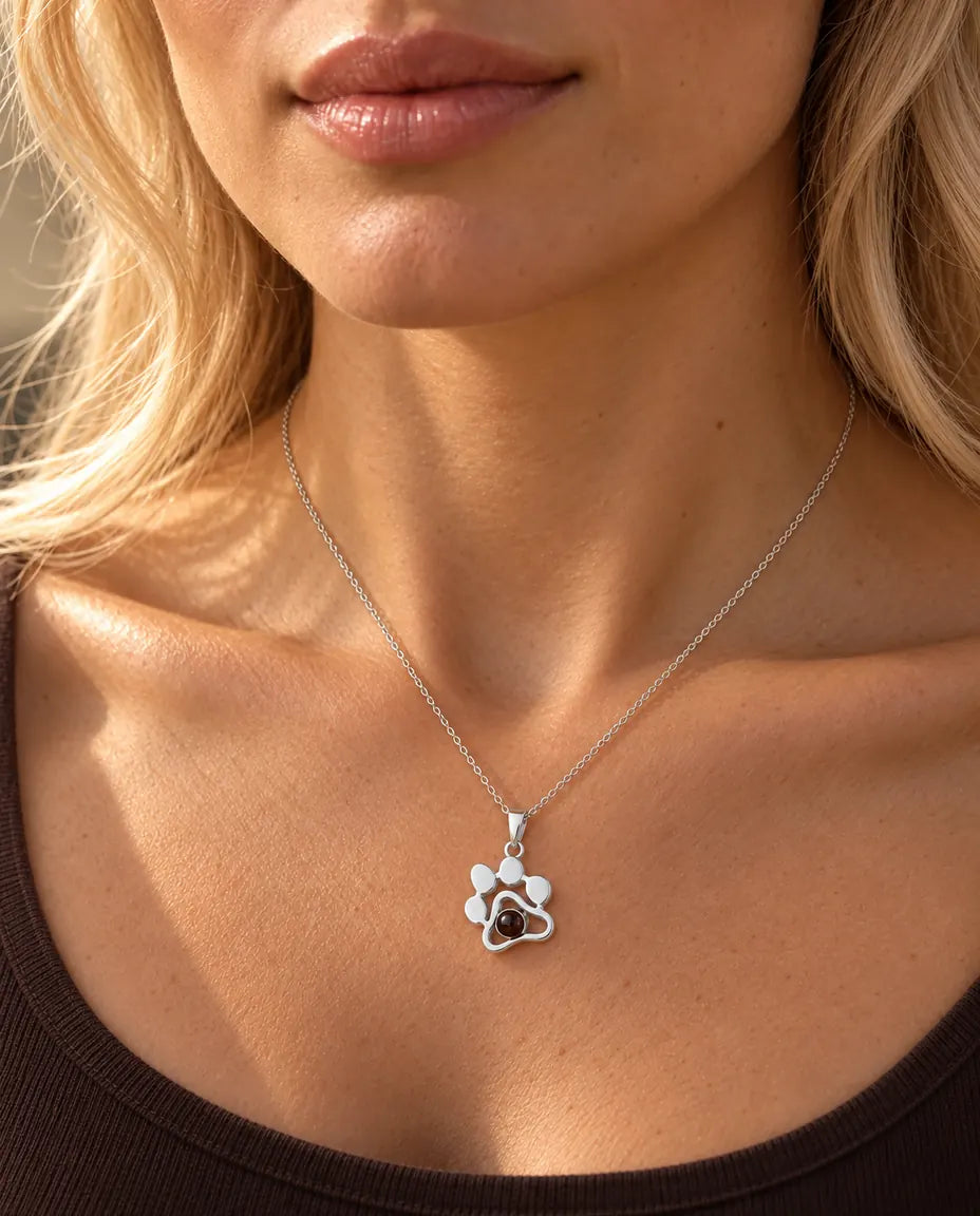 Mujer con un top marrón que lleva el collar de plata con huella y la foto de su mascota dentro