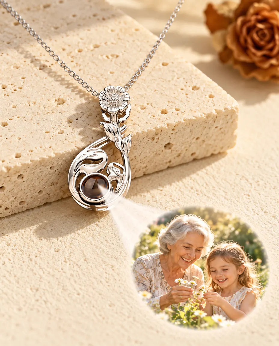 Collar de gota con flor plateado que proyecta la foto de una abuela con su nieta sobre yeso
