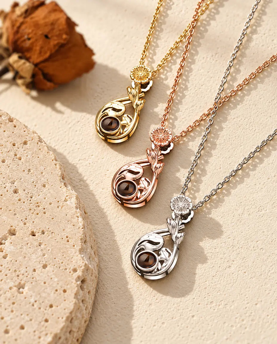 Collares de gota con flor en plateado, dorado y color oro rosa colocados en diagonal