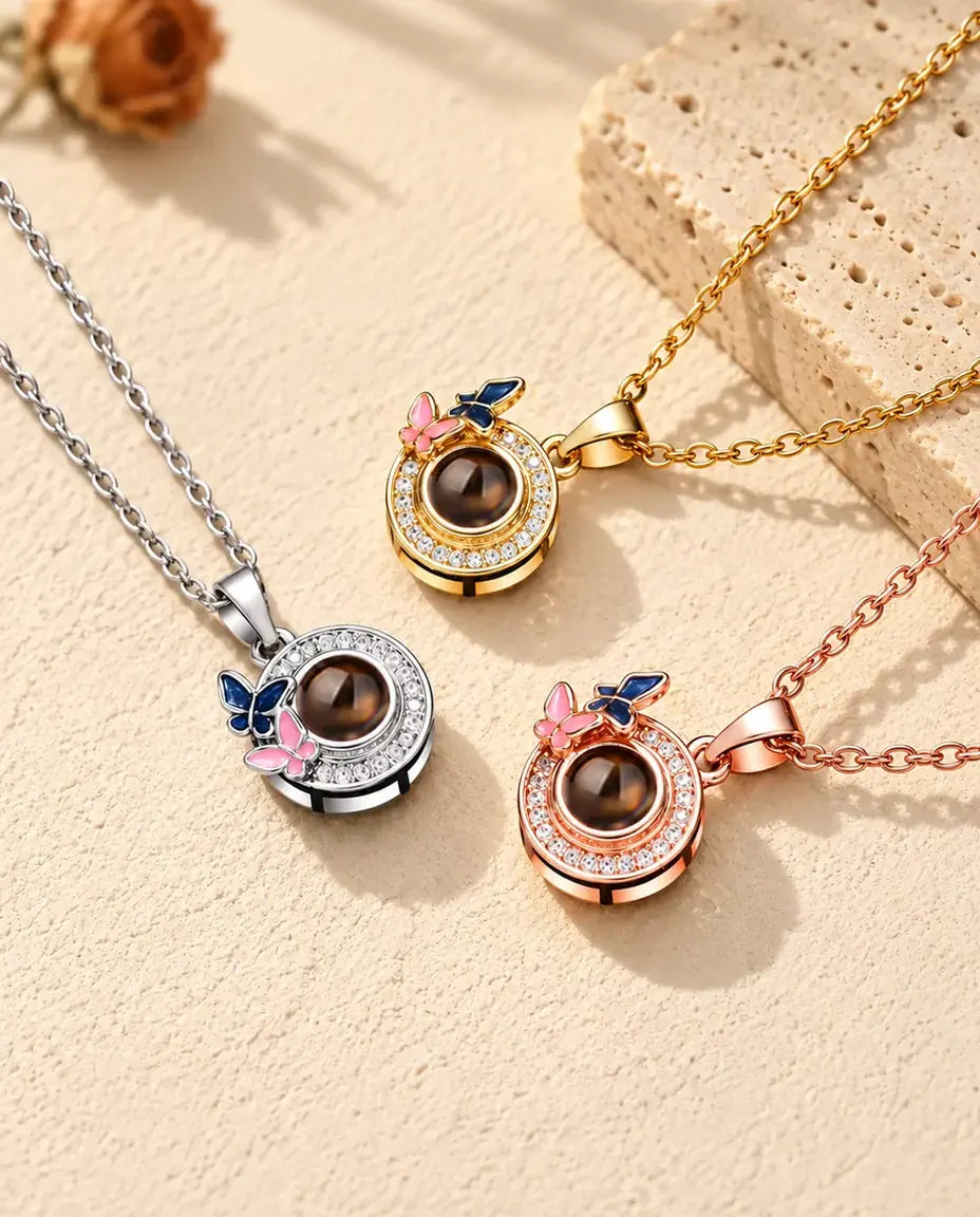 Collares de mariposas en dorado, plateado y color oro rosa, junto a una losa de travertino