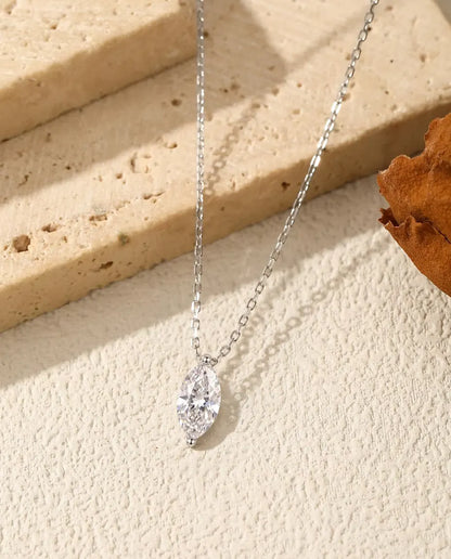 Collar de Moissanita Marquesa 1 ct en Plata 925 - colgante sobre el borde de una losa de travertino