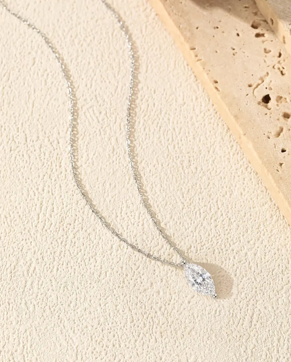 Collar de Moissanita Marquesa 1 ct en Plata 925 - en una curva suave sobre una superficie clara con textura