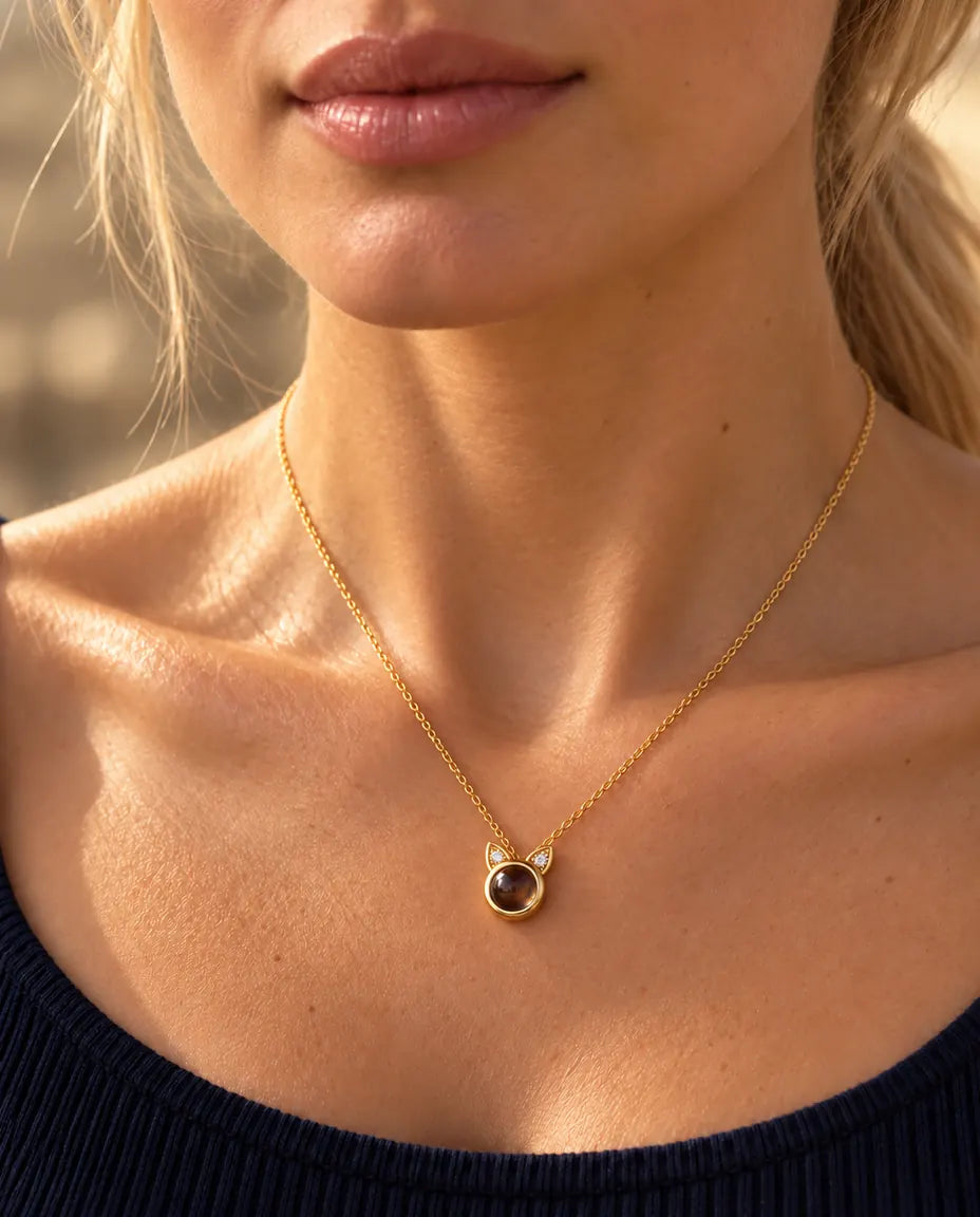 Mujer con un top azul marino que lleva el diminuto collar de orejas de gato dorado