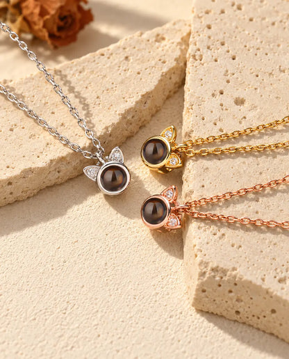 Collares mini de orejas de gato en plateado, dorado y color oro rosa sobre travertino