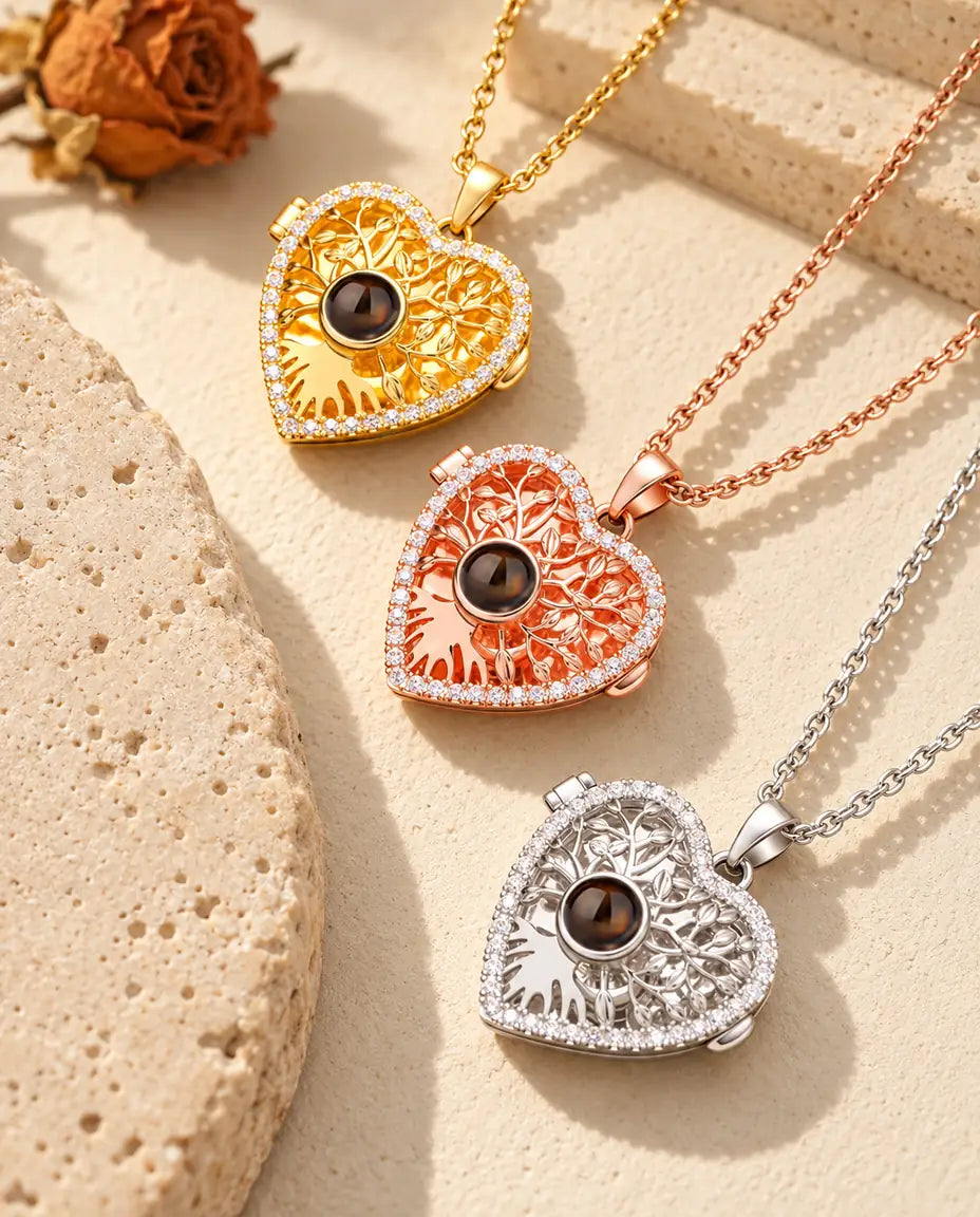 Relicarios de corazón en dorado, color oro rosa y plateado, dispuestos junto a una losa de travertino