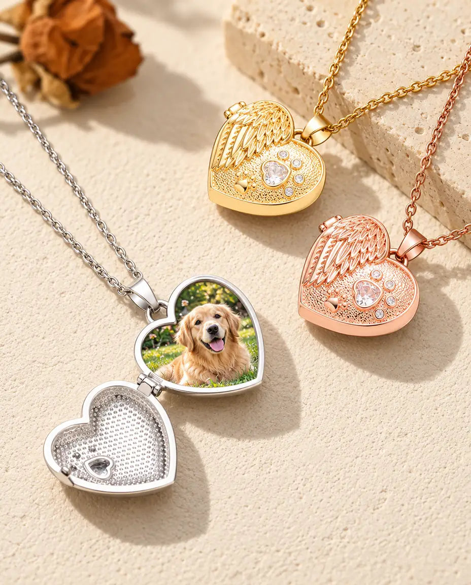 Relicario plateado abierto con la foto de un golden retriever, junto a dos relicarios cerrados dorado y color oro rosa