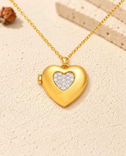 Vista frontal del relicario de corazón dorado con el corazón hundido de circonitas y la bisagra lateral