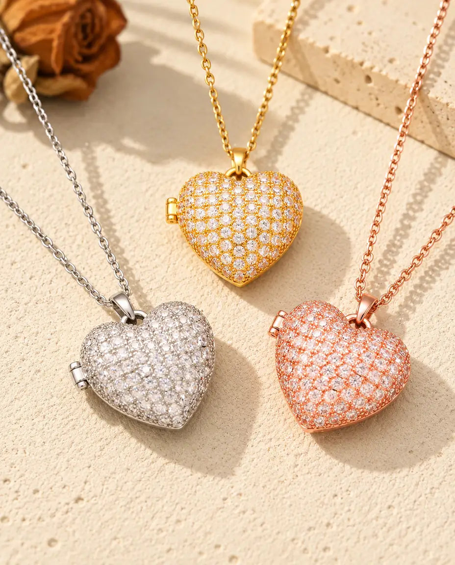 Los tres colores del collar relicario de corazón cuajado de circonitas, colocados juntos sobre yeso