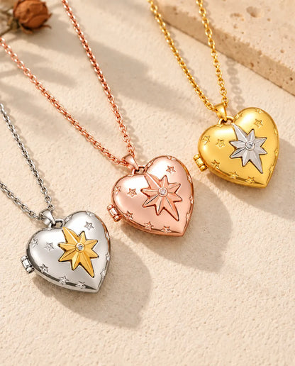 Relicarios de corazón con estrella polar en plateado, color oro rosa y dorado, colocados en diagonal sobre yeso crema