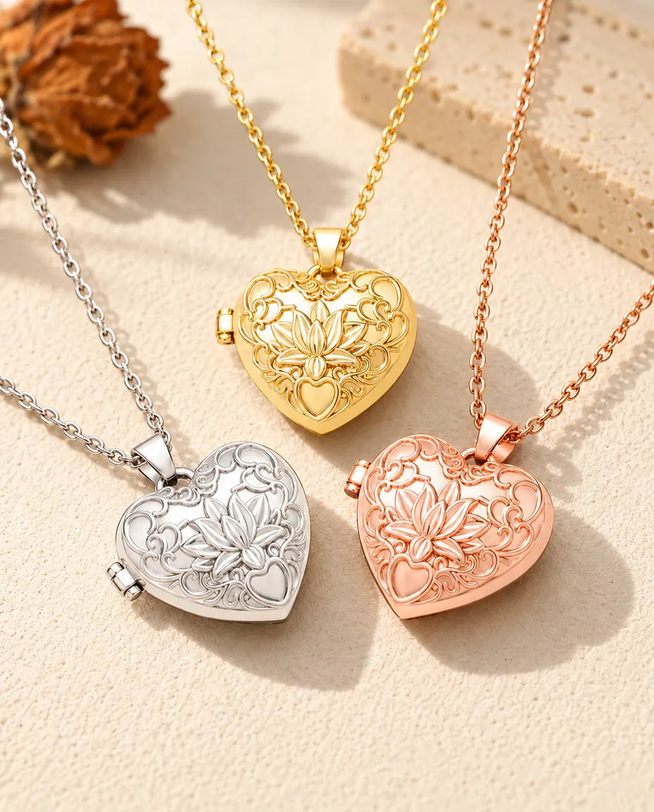 Los tres colores del collar relicario de corazón con flor de loto colocados juntos sobre yeso