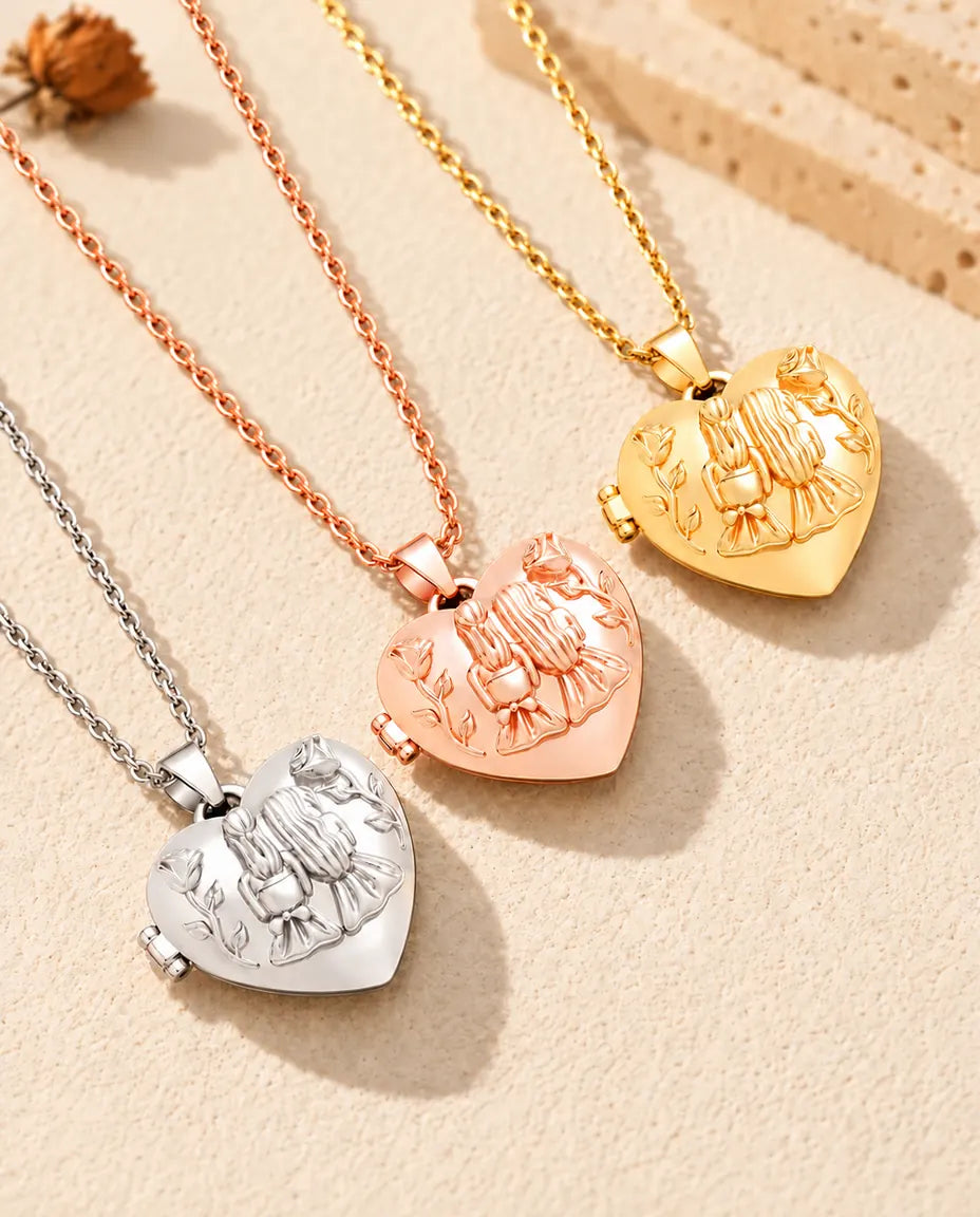Tres relicarios de corazón con dos hermanas, plateado, color oro rosa y dorado, colocados en diagonal sobre yeso crema