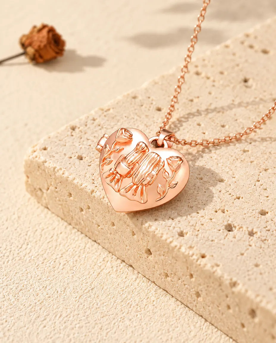 Collar relicario de corazón color oro rosa con dos hermanas sobre travertino con luz cálida de sol