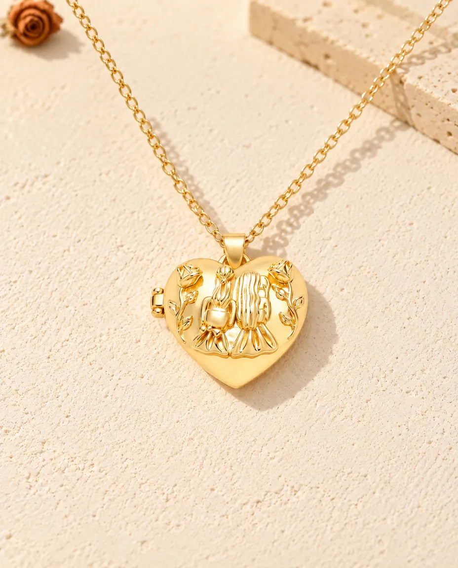 Vista frontal del relicario de corazón dorado con las dos chicas abrazadas, las rosas y la bisagra lateral