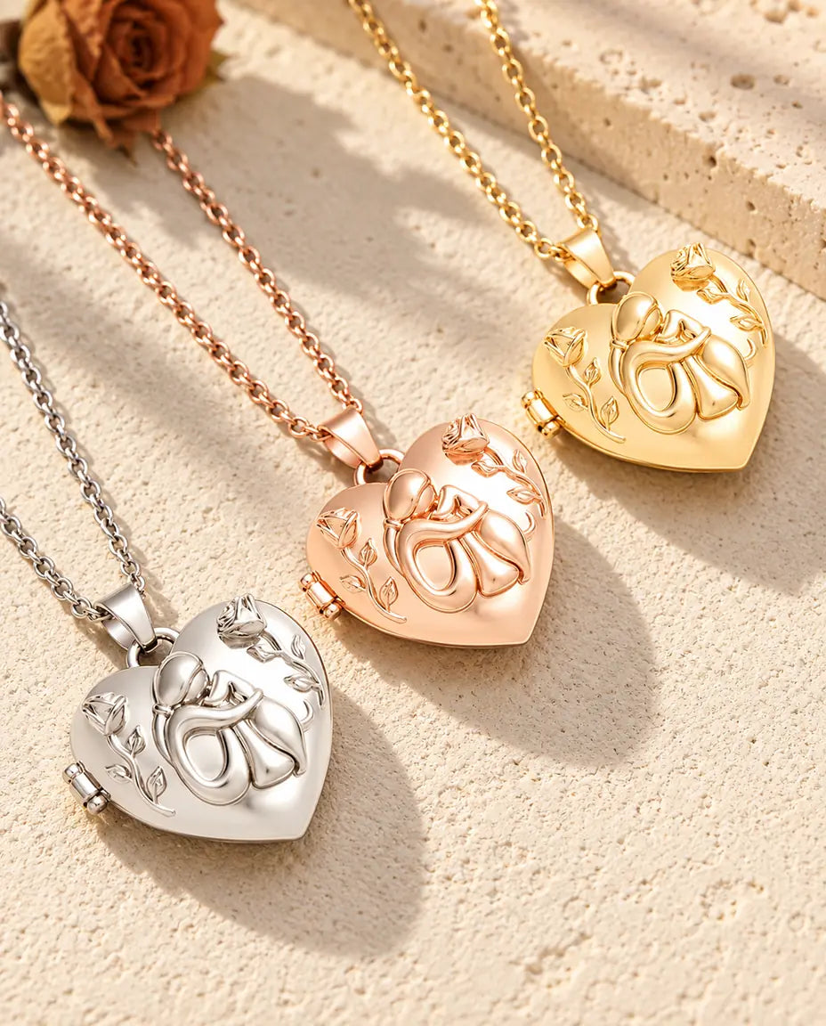 Tres relicarios de corazón con mujer y perro, plateado, color oro rosa y dorado, en diagonal sobre yeso crema