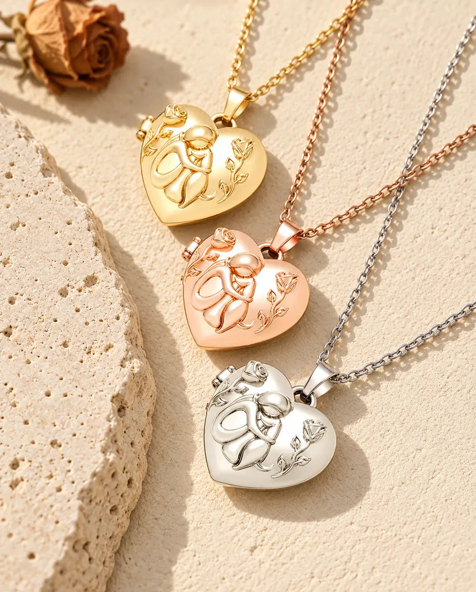 Relicarios de corazón con mujer y perro dorado, color oro rosa y plateado apilados junto a una losa de travertino