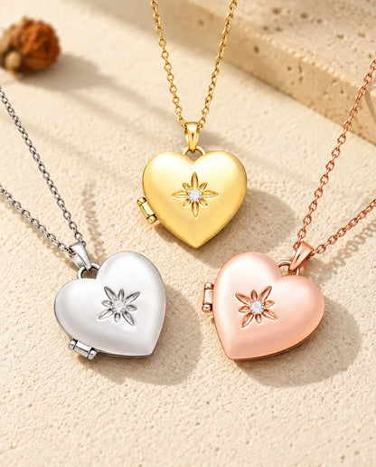 Los tres colores del collar relicario de corazón satinado con flor, colocados juntos sobre yeso