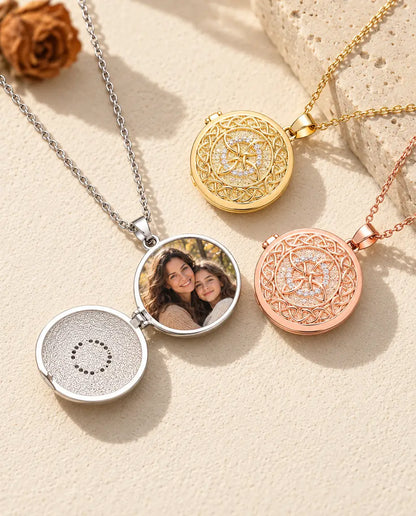 Relicario plateado abierto con una foto de madre e hija adolescente, junto a relicarios cerrados dorado y color oro rosa