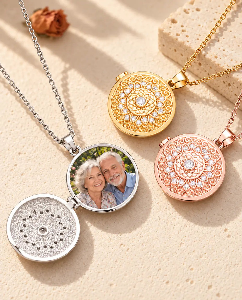 Relicario plateado abierto con una foto de dos abuelos dentro, junto a dos relicarios cerrados dorado y color oro rosa