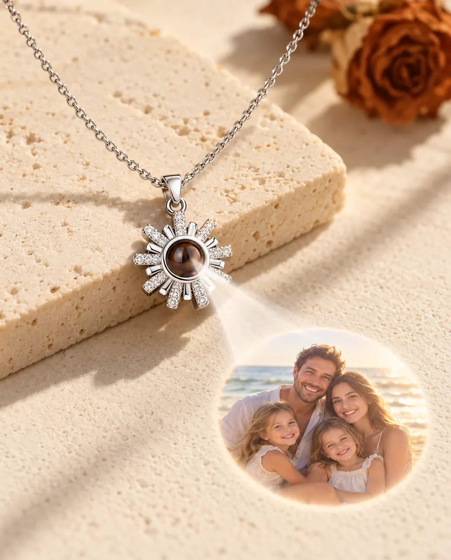 Collar de sol plateado que proyecta la foto de una familia en la playa sobre yeso crema