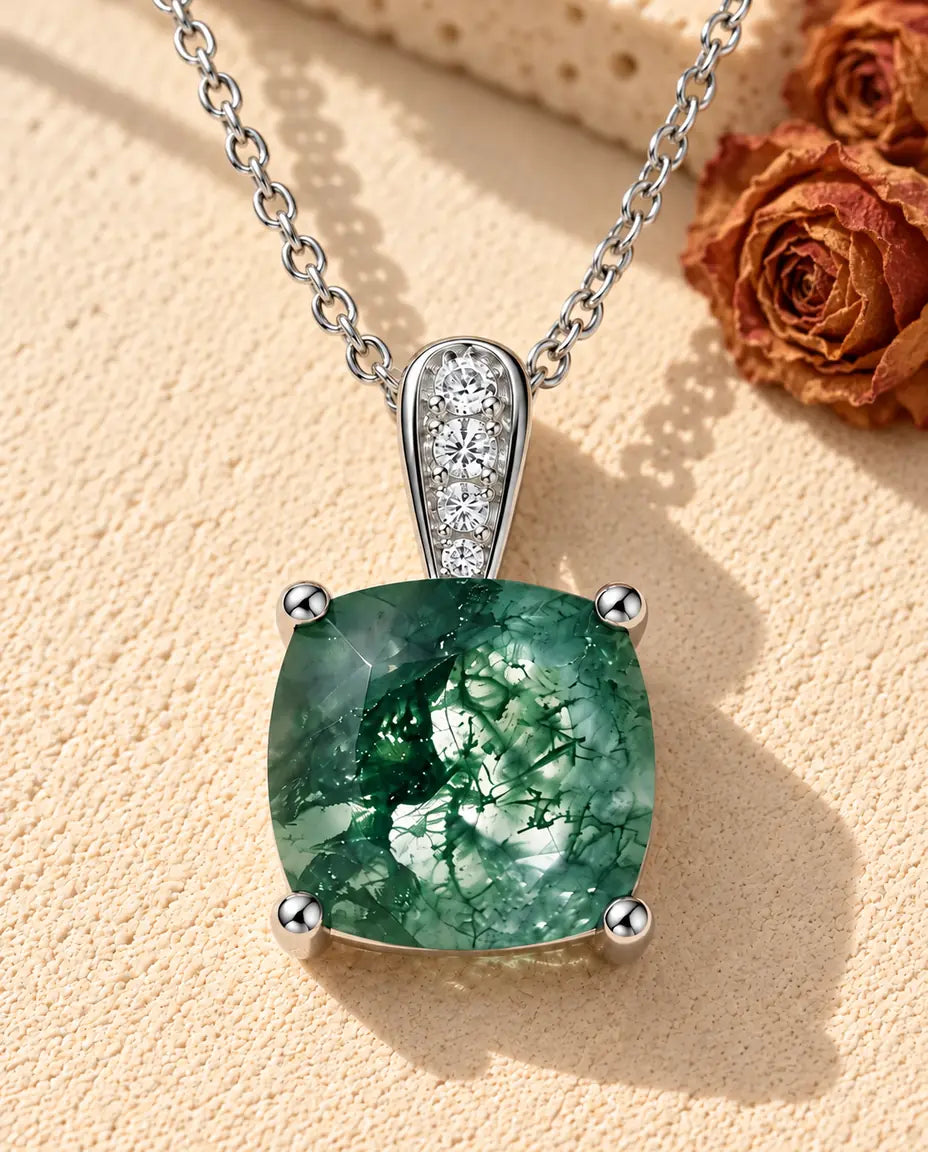 Collar Solitario de Ágata Musgosa en Plata 925 - sobre una superficie clara con textura junto a un bloque de travertino