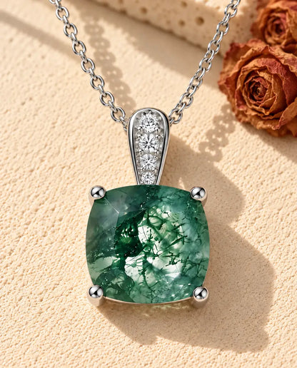 Collar Solitario de Ágata Musgosa en Plata 925 - sobre una superficie clara con textura junto a un bloque de travertino